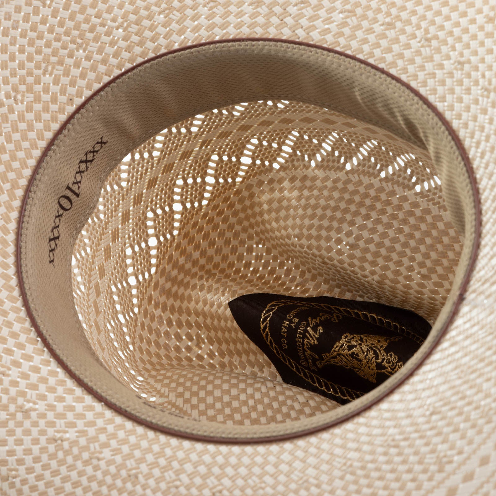 10X Cowboy Cruz tan and ivory cowboy hat closeup of the underside with yellowish interior, light brown trim and dark brown lettering