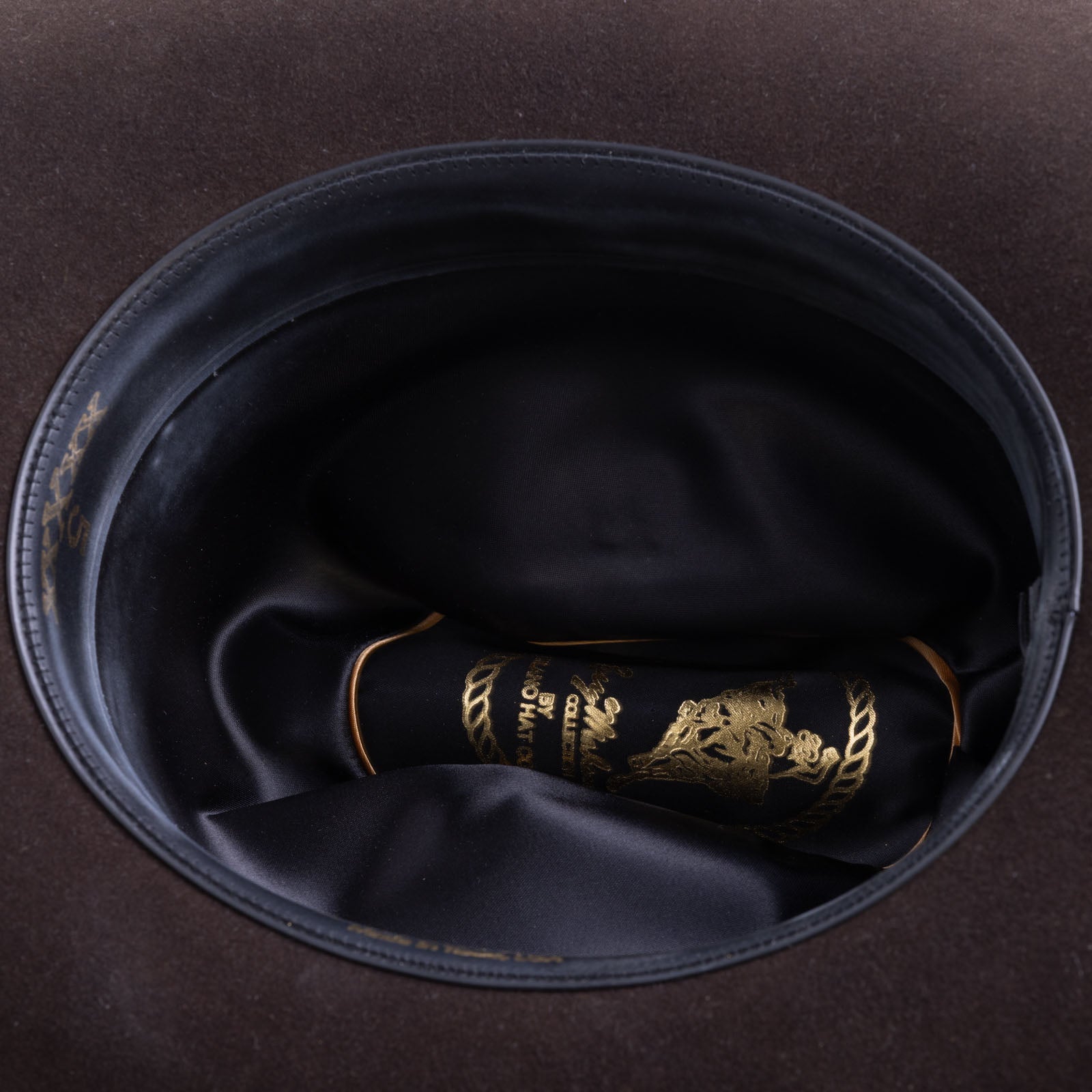 5X Dorado brown cowboy hat closeup of the underside with black interior and gold lettering