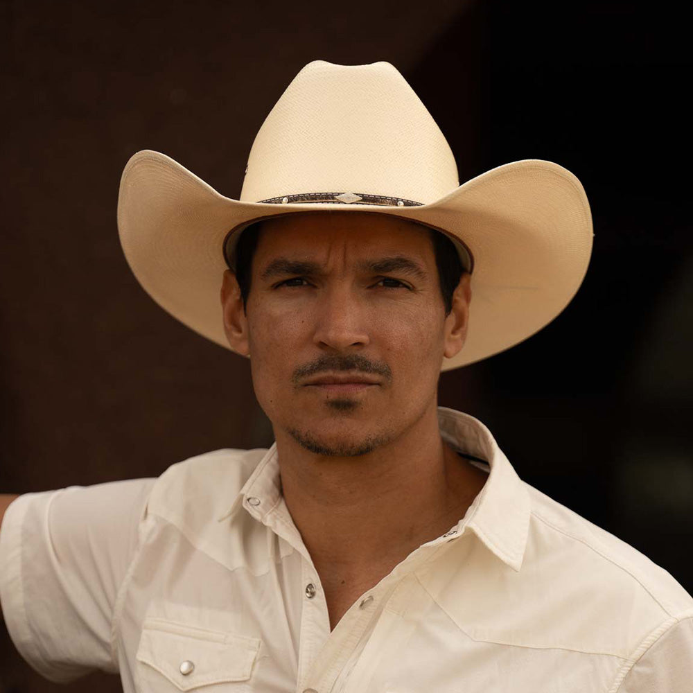 Man wearing a 10X Brindle brown cowboy hat with a white short sleeve shirt