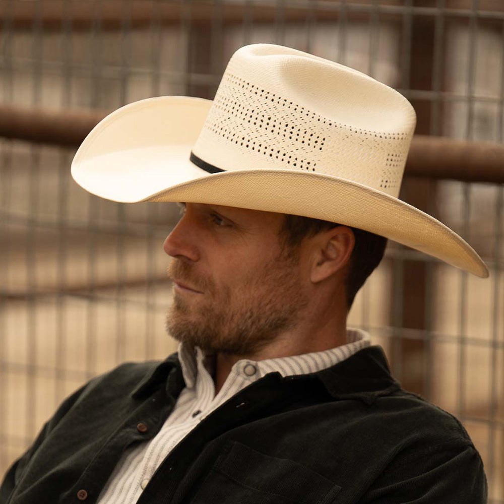 Bearded man wearing a 10X Cowboy Weston belly cowboy hat, black jacket, and white plaid shirt