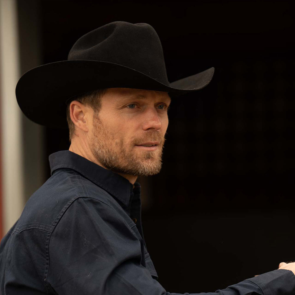 Bearded man wearing a 30X El Rey black cowboy hat and slate-colored long sleeve shirt