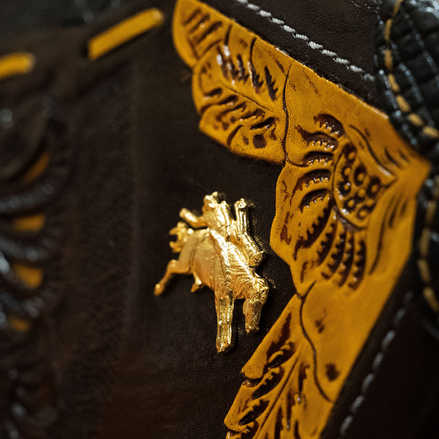 Closeup of the Larry Mahan cowboy hat box corner with him riding a horse as a golden pin
