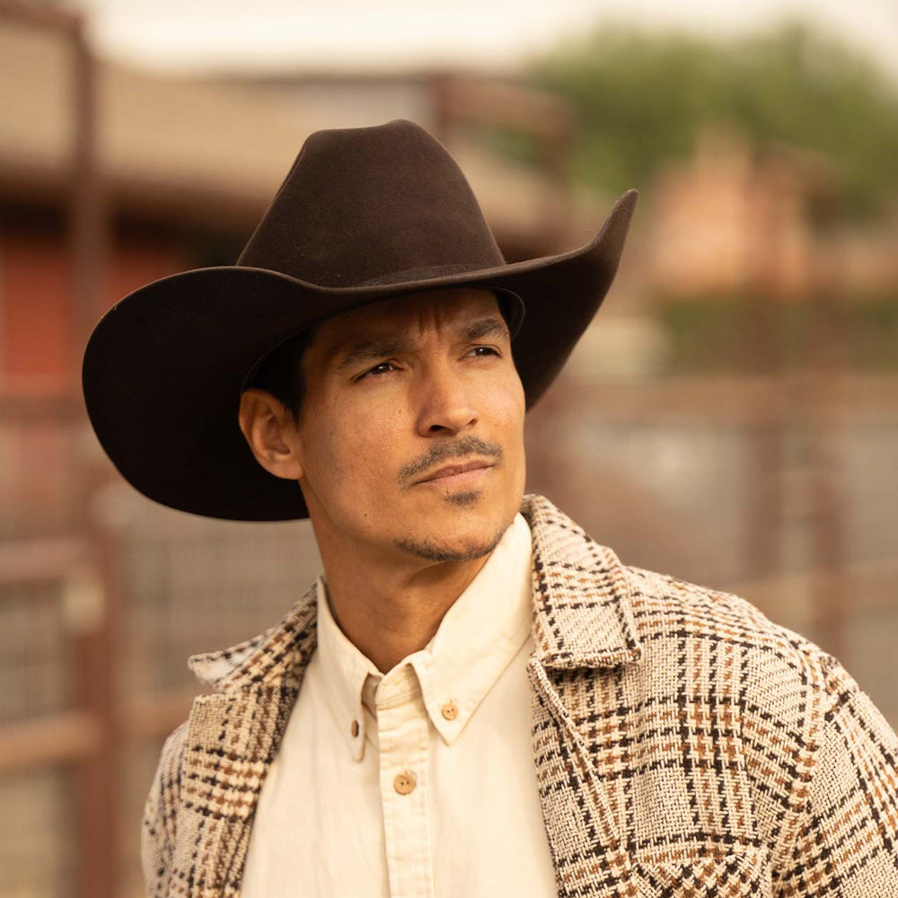 Man wearing a 6X Lockhart brown cowboy hat with a tan plaid jacket and white under shirt