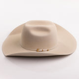 A light beige felt cowboy hat with a small gold buckle detail on the side, photographed on a clean light gray background