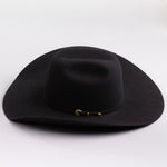 A black felt cowboy hat with a small gold buckle detail on the band, photographed on a clean light gray background