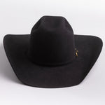 A black felt cowboy hat with a small gold buckle detail on the band, photographed on a clean light gray background