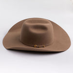 A classic felt cowboy hat in a fawn brown color, featuring a small gold-tone buckle on the band, set against a clean light gray background