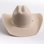 A light beige felt cowboy hat with a matching band and a small gold-toned buckle, photographed on a clean light gray background
