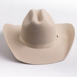 A light beige felt cowboy hat with a matching band and a small gold-toned buckle, photographed on a clean light gray background