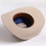 A light beige cowboy hat shown from a top-down angle, revealing a brown leather-like inner rim and a blue patterned interior lining