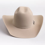 A light beige felt cowboy hat with a curved brim and a small silver buckle detail on the band, photographed on a clean light gray background