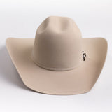 A light beige felt cowboy hat with a curved brim and a small silver buckle detail on the band, photographed on a clean light gray background