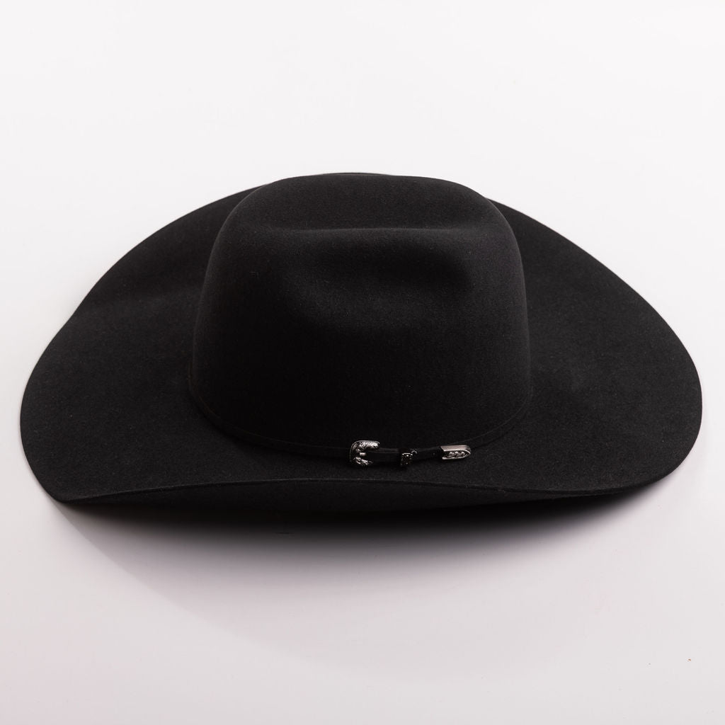 A black felt cowboy hat with a small silver decorative buckle on the band, photographed on a clean light gray background