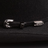 A close-up of a black felt hat featuring a decorative silver-toned metal buckle closure with a sculpted animal head design