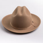 A classic felt hat in a fawn brown color, featuring a matching fabric band with a small decorative buckle, photographed on a light gray background
