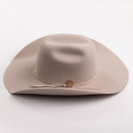 A light beige felt cowboy hat with a matching band and a small round gold-tone button, photographed on a clean light gray background