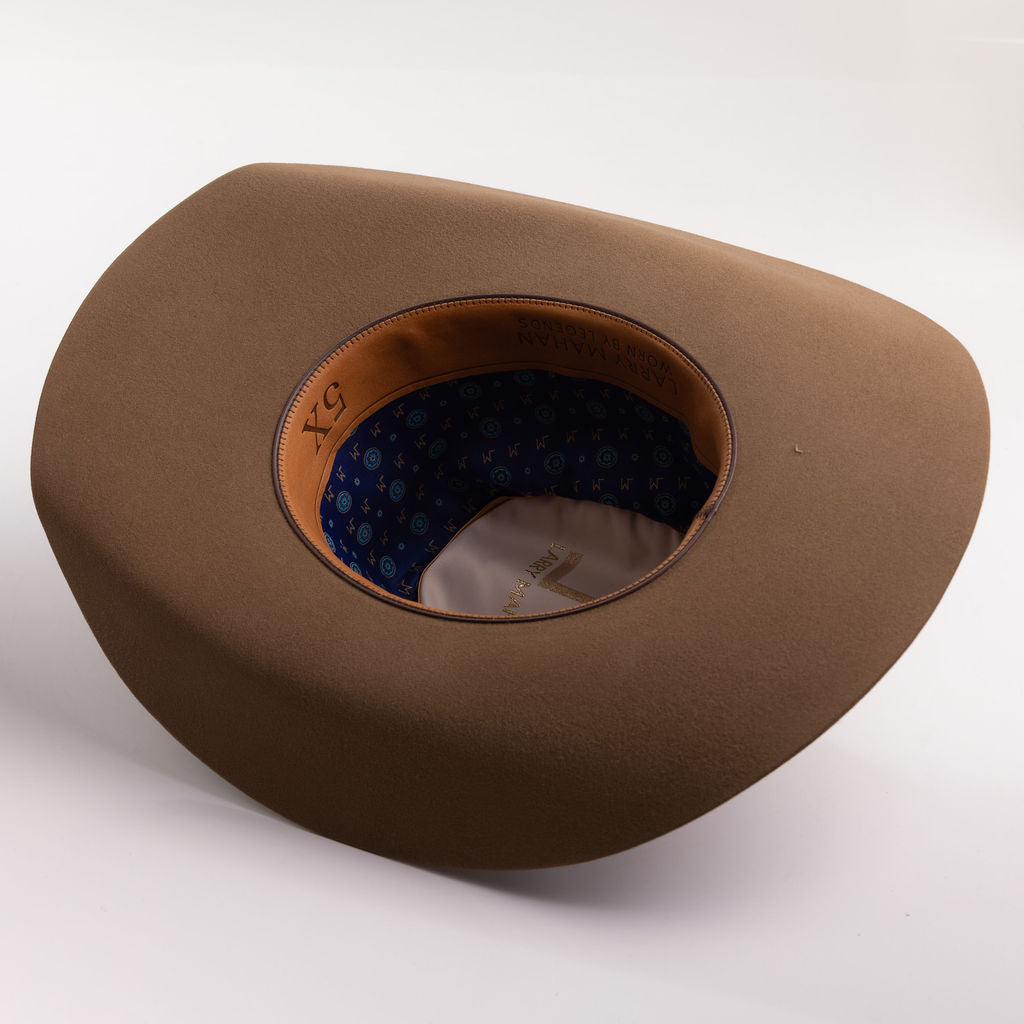 A brown wide-brimmed cowboy hat shown from an overhead angle, featuring a tan leather-like inner band and a blue patterned lining inside the crown