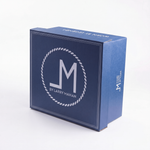 A blue branded product box with a white rope-style circular logo and the text "BY LARRY MAHAN" on the front, photographed on a clean white background