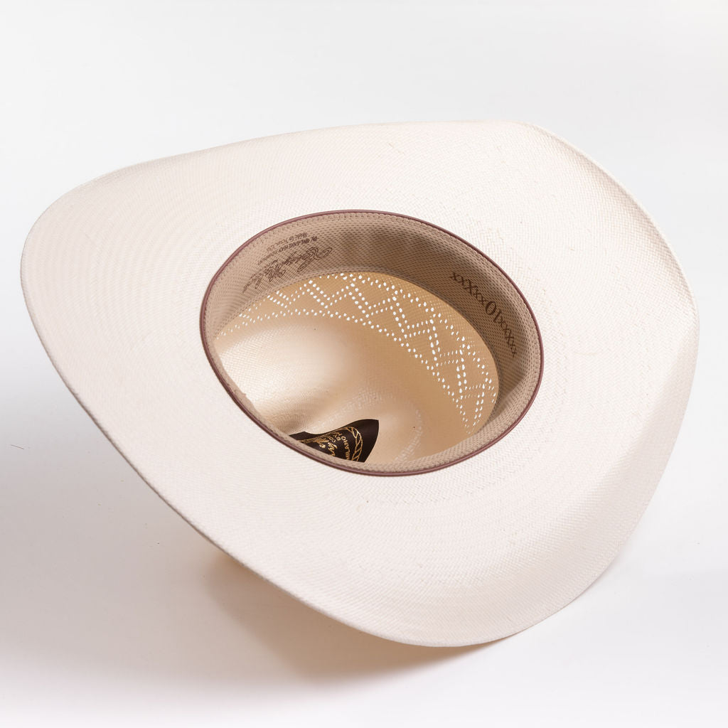 A cream-colored cowboy hat photographed from an overhead angle, showing the interior crown and a decorative dotted pattern on the inner band