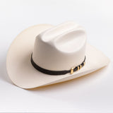 An off-white cowboy hat with a black band and gold buckle, photographed on a clean light gray background
