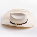 An off-white cowboy hat with a black band and gold buckle, photographed on a clean light gray background