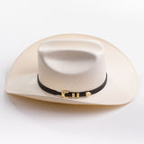 An off-white cowboy hat with a black band and gold buckle, photographed on a clean light gray background