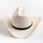 An off-white cowboy hat with a black band and gold buckle, photographed on a clean light gray background