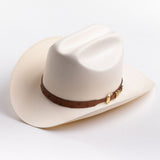 A cream-colored cowboy hat with a brown leather band and gold buckle, photographed on a clean light gray background