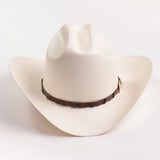 An off-white cowboy hat with a dark brown textured band, photographed on a clean white background