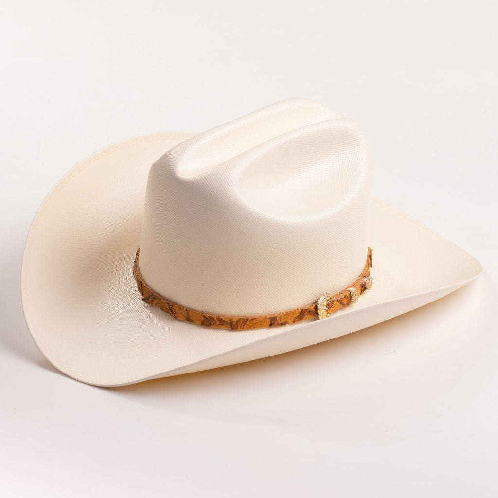 An off-white cowboy hat with a textured finish and a brown patterned band around the crown, shown against a plain white background