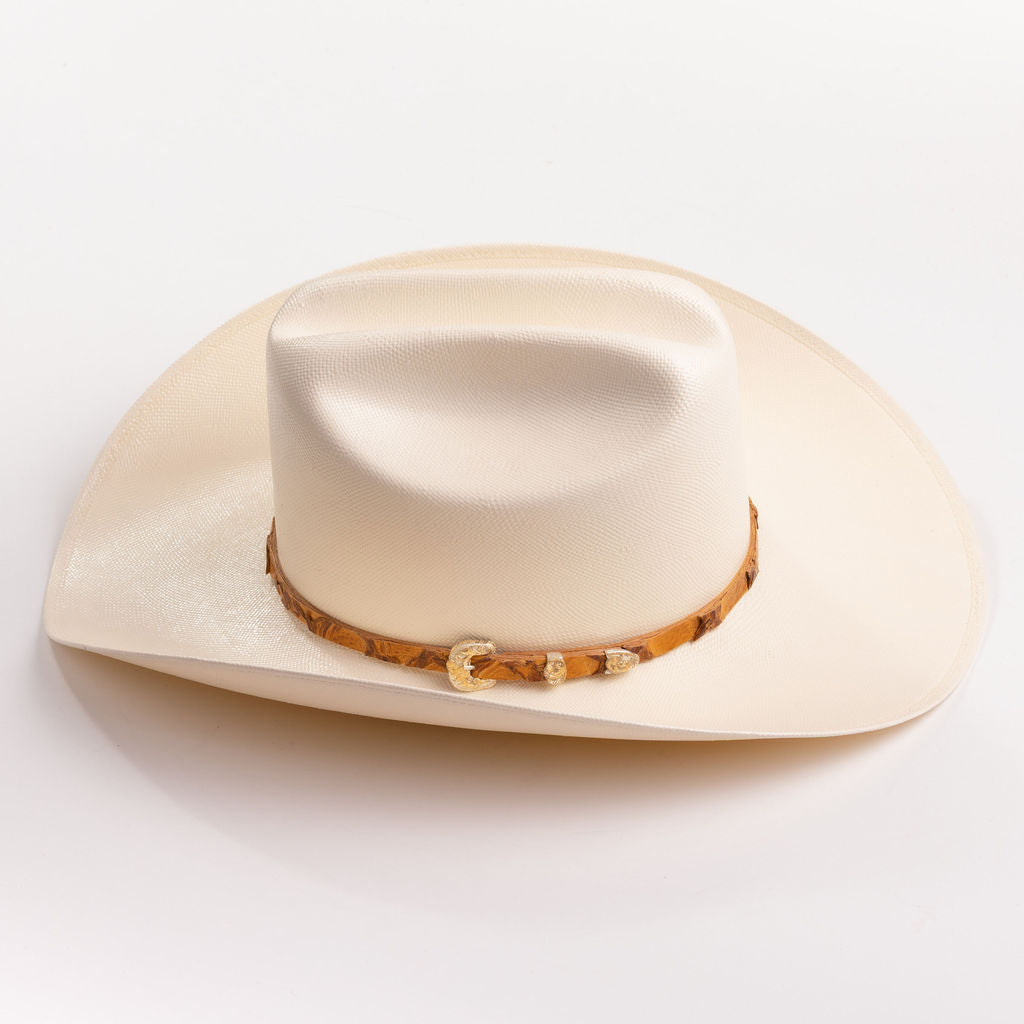 An off-white cowboy hat with a textured finish and a brown patterned band around the crown, shown against a plain white background