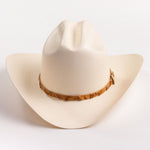 An off-white cowboy hat with a textured finish and a brown patterned band around the crown, shown against a plain white background
