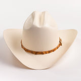 An off-white cowboy hat with a textured finish and a brown patterned band around the crown, shown against a plain white background