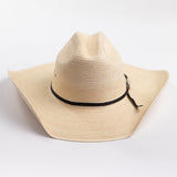 A light beige woven straw cowboy hat with a black ribbon band and a small silver buckle, photographed on a clean white background