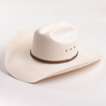 An off-white woven cowboy hat with a brown band and silver-toned studs, photographed on a clean white background