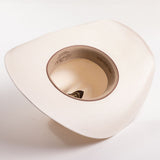 An underside of an off-white woven cowboy hat with a light brown interior with printed text, photographed against a clean white background