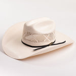 An off-white colored woven cowboy hat with a black ribbon band and a small gold logo tag, photographed on a clean white background