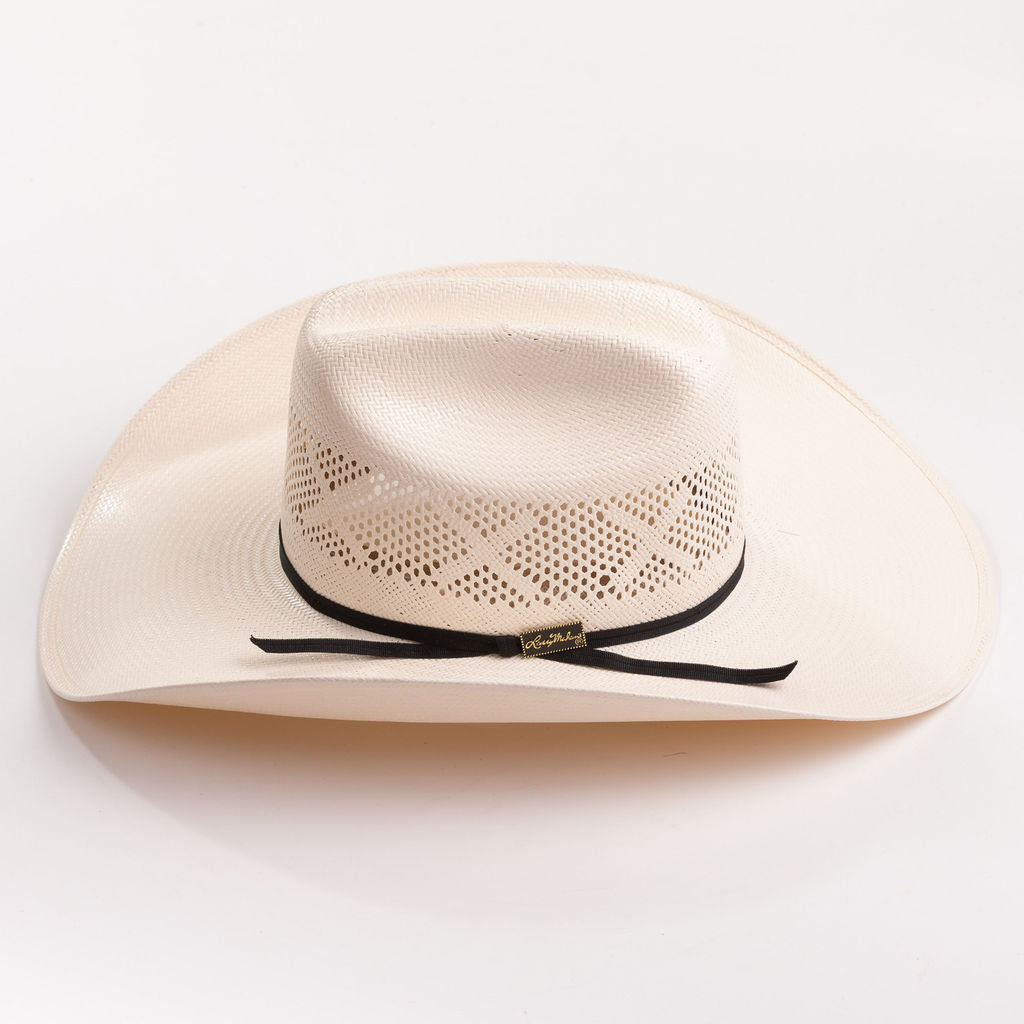 An off-white woven cowboy hat with a black ribbon band and a small gold brand tag, photographed on a clean white background.