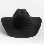 A black felt cowboy hat with a wide brim and a black band around the crown, featuring a small gold brand pin on the band, set against a clean light gray background.