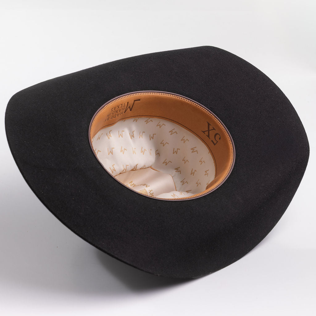 A black felt cowboy hat shown from a top-down angle, displaying its tan leather trim and cream-colored patterned interior lining
