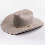 A light taupe felt cowboy hat with a matching felt crown and a beige fabric band around the middle, photographed on a clean light gray background