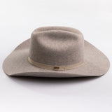 A light taupe felt cowboy hat with a matching felt crown and a beige fabric band around the middle, photographed on a clean light gray background