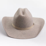A light taupe felt cowboy hat with a matching felt crown and a beige fabric band around the middle, photographed on a clean light gray background