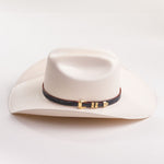 Ivory cowboy hat with a black and gold band on a light gray background