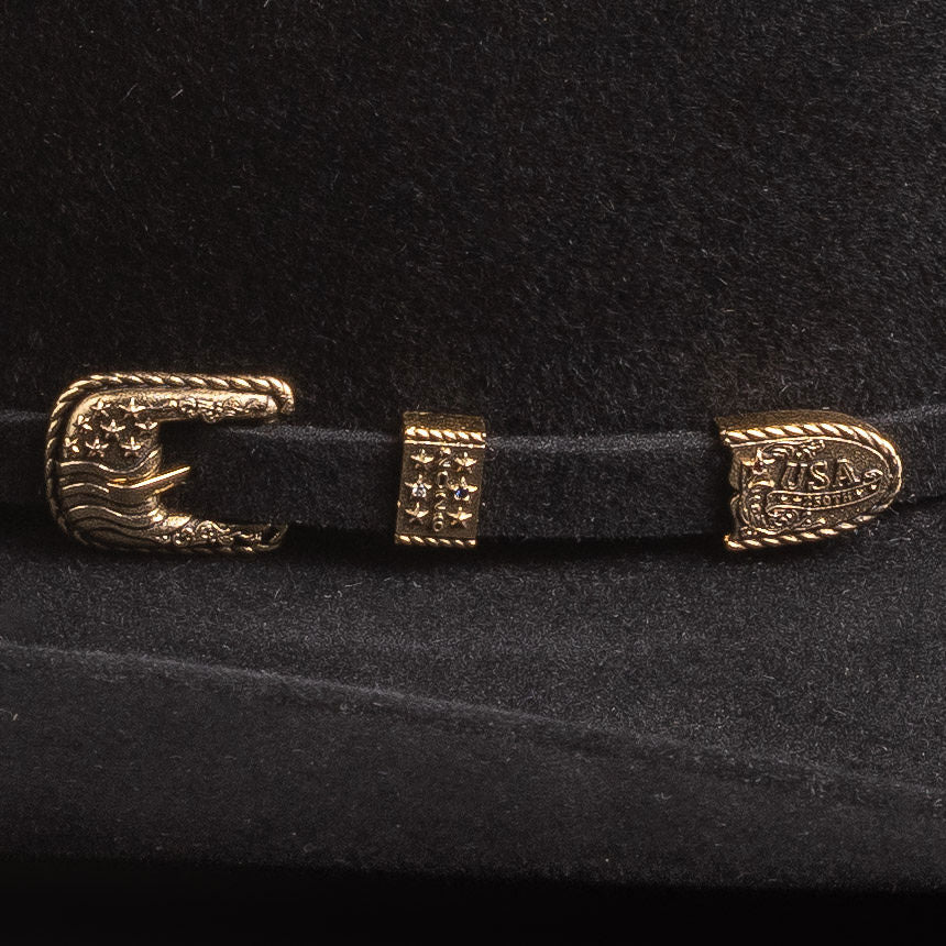 Close-up of a black belt with gold buckle