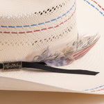 Close-up of a straw hat with decorative band and feather, featuring the brand 'Larry Mahan's'