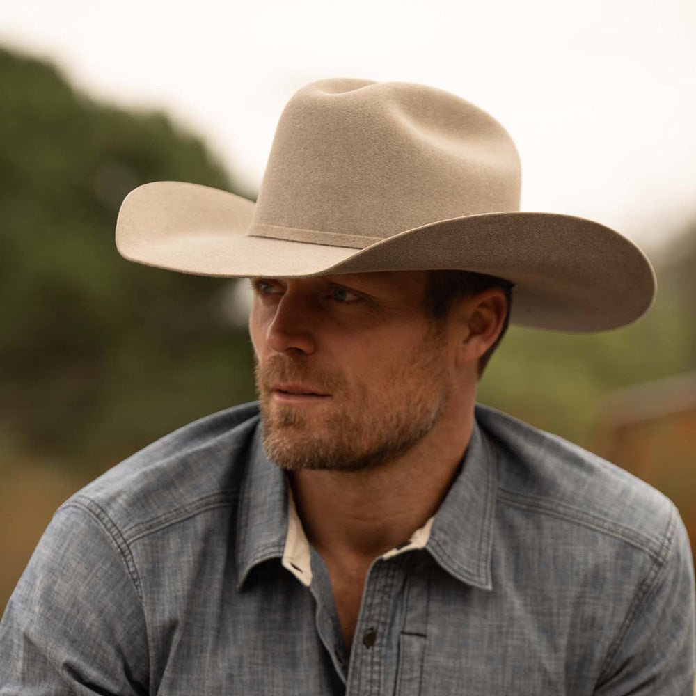 Bearded man wearing a 5X Fort Worth natural cowboy hat and blue long sleeve shirt
