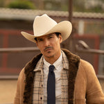 Man wearing a 500X Superior belly cowboy hat with a brown jacket with blue tie and white shirt
